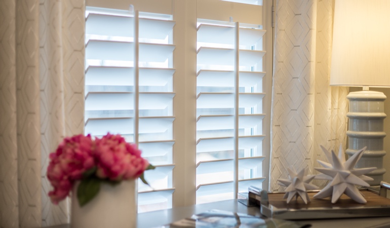 Plantation shutters by flowers in Southern California